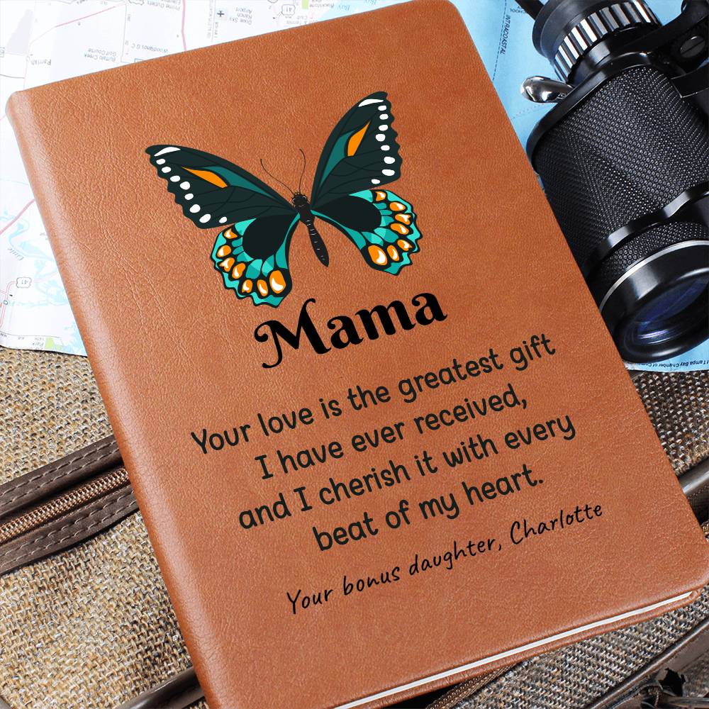 Brown leather notebook with butterfly design and engraved text, placed on a textured surface with a camera in the background.