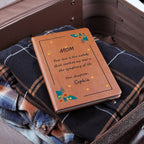 Brown leather notebook with engraved message on plaid fabric