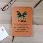 Brown leather notebook with butterfly design and engraved text on a wooden surface.