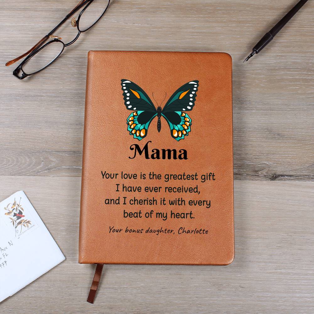 Brown leather notebook with butterfly design and engraved text on a wooden surface.