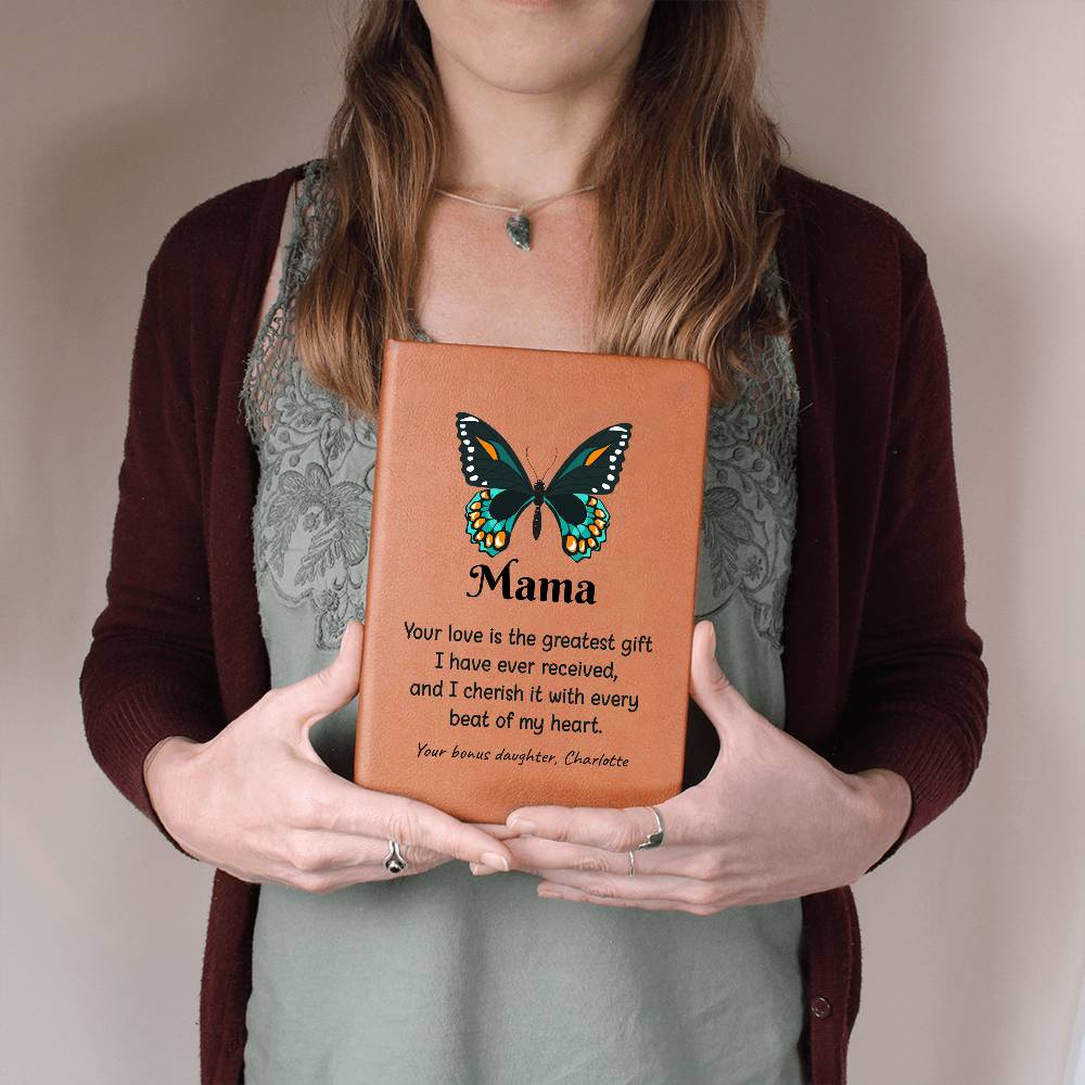 Person holding a leather-bound book with a butterfly design and text, against a neutral background.
