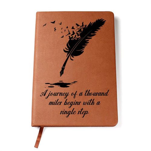 Brown notebook with feather and inkwell design and motivational quote on a white background