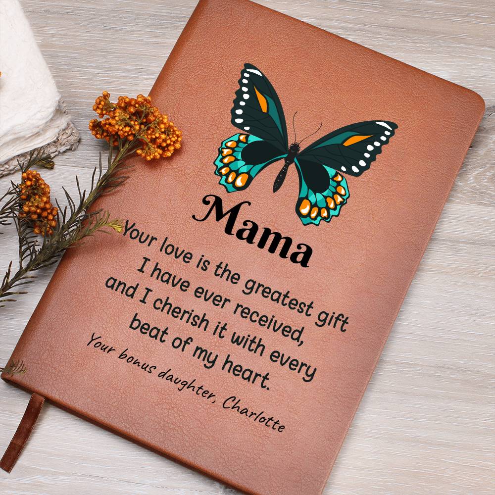 Brown leather notebook with a butterfly design and heartfelt message on a wooden surface.